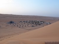 Poušť  Wahiba sands.  Arabian Oryx Camp - zde dnes nocujeme. Camp je asi 250 m výškově pod námi. To ještě netušíme, že naši řidiči si to namíří s auty přímo dolů. : Wahiba sands.